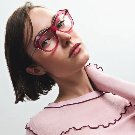 Jeune femme portant des lunettes roses designé par MSD à Montréal, posant en gros plan avec un pull rose.