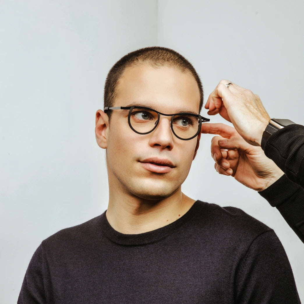 Jeune homme aux yeux verts portant des lunettes noires sur mesure Bar à Lunettes